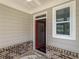 Covered porch featuring a red front door, brick accents, and a window at 1977 Boyd Trace Nw Ln, Atlanta, GA 30318