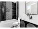Chic bathroom with modern black and white tile, a stylish vanity, and a sleek bathtub and shower combo at 387 S Howard Se St, Atlanta, GA 30317