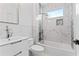 Modern bathroom featuring marble tile, sleek white vanity, and bathtub with shower at 387 S Howard Se St, Atlanta, GA 30317