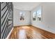Well-lit bedroom with hardwood floors, stylish geometric accent wall and electric fireplace at 387 S Howard Se St, Atlanta, GA 30317