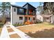 Modern two-story home boasts a striking black and white facade, wood accents, manicured lawn, and inviting front porch at 387 S Howard Se St, Atlanta, GA 30317