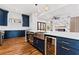 Modern kitchen with navy cabinets, stainless steel appliances, large island, and marble backsplash at 387 S Howard Se St, Atlanta, GA 30317