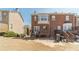 Back view of a brick townhome with a patio and stairs leading to the upper floors at 2164 Mill Garden Run, Buford, GA 30519