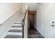 Hallway with stairs, hardwood floors, white walls, and a door with wood slats leading to another room at 2164 Mill Garden Run, Buford, GA 30519