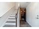 Hallway with stairs, hardwood floors, white walls, and a door with wood slats leading to an office space at 2164 Mill Garden Run, Buford, GA 30519