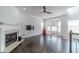Bright living room with dark hardwood floors, fireplace, large windows, and a modern ceiling fan at 2164 Mill Garden Run, Buford, GA 30519