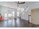 Bright, open living room with hardwood floors, large bay window, and a modern ceiling fan and staircase at 2164 Mill Garden Run, Buford, GA 30519