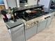 Kitchen island features a cooktop with gas burners and dark stone countertops and gray cabinets at 3810 Galloway Dr, Roswell, GA 30075