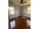 Bright bedroom with hardwood floors, ceiling fan, and windows allowing ample natural light at 407 Hilltop Dr, Forest Park, GA 30297
