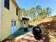 Backyard featuring a patio with a grill and a yellow house at 4722 Bradford Ln, Powder Springs, GA 30127