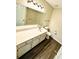 Clean bathroom with a large mirror, wooden floors, white cabinets, and a toilet at 4722 Bradford Ln, Powder Springs, GA 30127