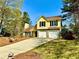 Charming two-story yellow home with a well-maintained front yard and two-car garage at 4722 Bradford Ln, Powder Springs, GA 30127