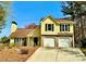 Inviting two-story yellow home with a well-maintained front yard and two-car garage at 4722 Bradford Ln, Powder Springs, GA 30127