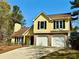 Charming two-story home with a two-car garage and a well-manicured front yard on a sunny day at 4722 Bradford Ln, Powder Springs, GA 30127
