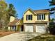 Inviting two-story yellow home with a well-maintained front yard and two-car garage at 4722 Bradford Ln, Powder Springs, GA 30127