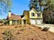 Charming two-story yellow home with a two-car garage and driveway on a sunny day at 4722 Bradford Ln, Powder Springs, GA 30127