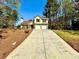 View of a yellow two-story house with a driveway and a two-car garage on a sunny day at 4722 Bradford Ln, Powder Springs, GA 30127
