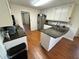 Bright kitchen with stainless appliances, granite countertop, and wood tile floor at 4722 Bradford Ln, Powder Springs, GA 30127