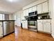 Kitchen with stainless steel appliances, white cabinets, granite countertops and wood-look floors at 4722 Bradford Ln, Powder Springs, GA 30127
