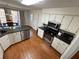 Open kitchen with granite counters, stainless appliances, white cabinets, and breakfast area with wood-look floors at 4722 Bradford Ln, Powder Springs, GA 30127