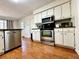 Well-lit kitchen features updated stainless steel appliances and white cabinetry, with wood-look flooring at 4722 Bradford Ln, Powder Springs, GA 30127