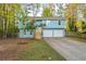 Charming two-story home with a light blue exterior, a well-maintained lawn, and an attached two-car garage at 5030 Sumit Wood Dr, Kennesaw, GA 30152