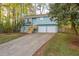 Home exterior with light blue siding, two-car garage, and wooden stairs leading to the front door at 5030 Sumit Wood Dr, Kennesaw, GA 30152
