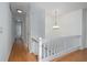 Bright hallway with hardwood floors, white walls, a staircase with white railings, and modern lighting fixtures at 5030 Sumit Wood Dr, Kennesaw, GA 30152