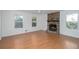 Bright living room with hardwood floors, white walls, a ceiling fan, a stone fireplace and two large windows at 5030 Sumit Wood Dr, Kennesaw, GA 30152