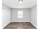 A simple bedroom features gray walls, modern ceiling light and wood-look floors at 5848 Dunn Sw Rd, Mableton, GA 30126