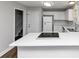 Open kitchen featuring white cabinets, stainless appliances, and a view of the staircase at 5848 Dunn Sw Rd, Mableton, GA 30126