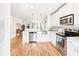 Open concept kitchen with stainless steel appliances, farmhouse sink and hardwood floors overlooks living spaces at 955 Bouldercrest Se Dr, Atlanta, GA 30316