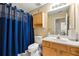 Bathroom with shower and bathtub with blue curtain, vanity, sink and mirror at 1395 Brisbane Dr, Dacula, GA 30019