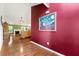 Inviting foyer showcasing hardwood floors, a bold red accent wall, and seamless access to the living area at 1395 Brisbane Dr, Dacula, GA 30019