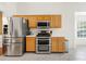 Stainless steel refrigerator and oven range with light wood cabinets and tile floor at 1395 Brisbane Dr, Dacula, GA 30019