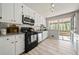 Cozy kitchen featuring white cabinets, subway tile backsplash, granite countertops, and backyard access at 1755 Fairburn Sw Rd, Atlanta, GA 30331