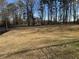Expansive grassy backyard featuring scattered trees under a clear sky, perfect for outdoor activities at 5720 Crow Dr, Cumming, GA 30041
