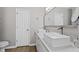 Modern bathroom featuring dual sinks with sleek white cabinets and a large mirror at 5720 Crow Dr, Cumming, GA 30041
