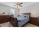 Comfortable bedroom with ceiling fan, large window and dark wood furnishings at 5720 Crow Dr, Cumming, GA 30041