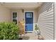 Inviting home entrance with a blue front door, rocking chair, and neat landscaping at 5720 Crow Dr, Cumming, GA 30041