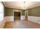 Traditional dining room with wood floors, modern wainscoting, and stylish chandelier at 1250 Great Oaks Se Dr, Conyers, GA 30013