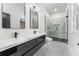 Modern bathroom featuring a double vanity with black cabinets and a glass enclosed shower with marble tile at 1569 Montreat Sw Ave, Atlanta, GA 30311