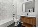 Contemporary bathroom featuring a wood vanity with white countertop and a black hexagon tile shower at 1569 Montreat Sw Ave, Atlanta, GA 30311
