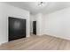 Empty bedroom featuring light hardwood floors and dark double doors at 1569 Montreat Sw Ave, Atlanta, GA 30311