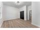 Bright bedroom featuring hardwood floors, a modern light fixture, and a dark closet door at 1569 Montreat Sw Ave, Atlanta, GA 30311