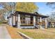 A charming house with inviting front porch, black trim and stone accents offers a warm welcome at 1569 Montreat Sw Ave, Atlanta, GA 30311