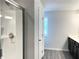 Bathroom with glass-enclosed shower, window, single sink and dark cabinets at 258 Station Overlook Dr, Auburn, GA 30011