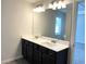Bathroom featuring a double vanity with dark cabinets, white countertop, and a large mirror at 258 Station Overlook Dr, Auburn, GA 30011