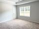 Bright bedroom with neutral walls, plush carpet, and large window letting in natural light at 258 Station Overlook Dr, Auburn, GA 30011