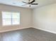 Bedroom showcasing wood-look flooring, a ceiling fan, and a large window at 258 Station Overlook Dr, Auburn, GA 30011